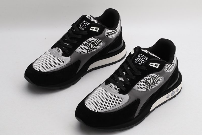 A pair of black, white, and grey athletic sneakers with prominent "LOUIS VUITTON PARIS" branding on the tongue, white mesh panels, black suede overlays, and grey accents on the sides, displayed from a top-down angle against a plain white background.