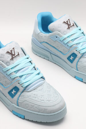 A single light blue Louis Vuitton LV Trainer Low-Top Sneaker, showcasing its embossed monogram on light blue leather, light blue and darker blue accents, and white sole.