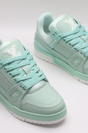 A pair of mint green Louis Vuitton LV Trainer Low-Top Sneakers, showcasing their full design from a slight angle.
