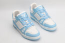 A pair of Louis Vuitton LV Trainer Low-Top Sneakers in white and light blue, viewed from an elevated angle, with the left shoe on its side showing the outsole with "VUITTON" branding.