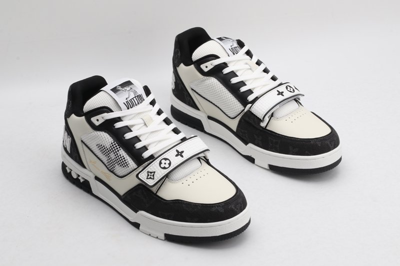 A pair of Louis Vuitton LV Trainer Mid-Top Sneakers in white and black monogram canvas, viewed from an elevated angle, showcasing both shoes with black monogram canvas panels, white and cream leather details, and a prominent white strap.