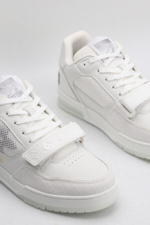 A pair of Louis Vuitton LV Trainer Mid-Top Sneakers in white and grey, viewed from an elevated angle, showcasing both shoes with white leather and mesh panels, grey suede accents, and a prominent white strap.