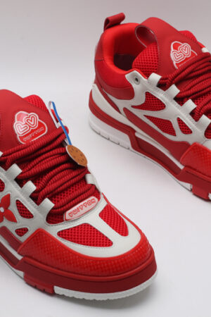 A single red and white Louis Vuitton LV Trainer sneaker, showcasing its vibrant color blocking, mesh panels, and robust sole.