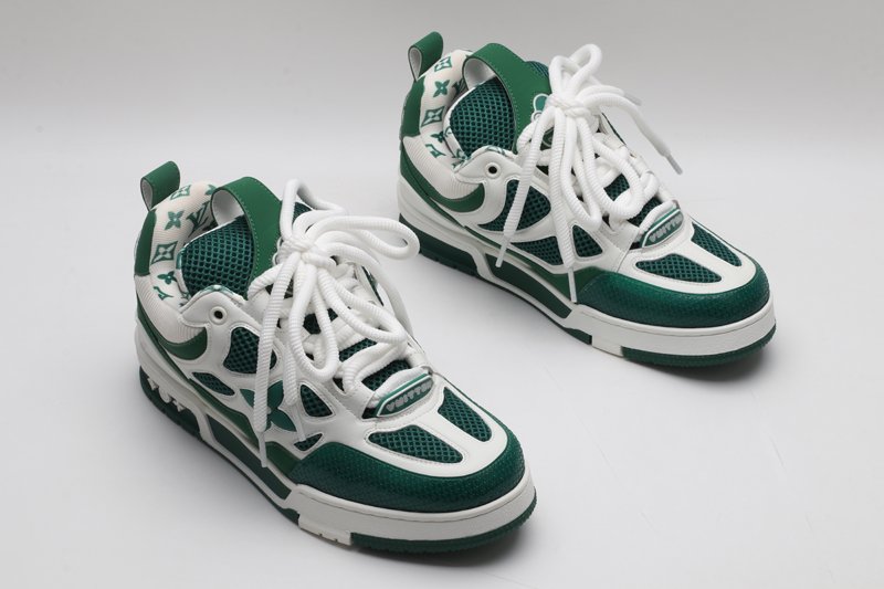 A single white and green Louis Vuitton LV Trainer sneaker, showcasing its bicolor design, mesh panels, and robust outsole.