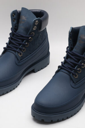 A pair of navy blue Timberland x Louis Vuitton collaborative waterproof boots, featuring the Timberland tree logo and subtle Louis Vuitton monogram debossing on the upper
