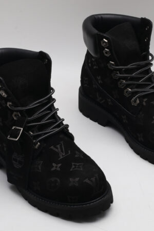 A single black Timberland x Louis Vuitton collaborative waterproof boot, featuring an all-over debossed Louis Vuitton monogram on suede, with silver eyelets and a black padded collar.