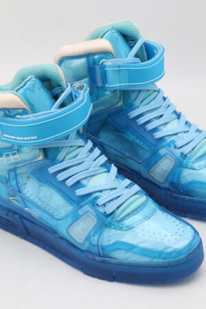 A pair of vibrant translucent azure blue high-top sneakers with white accents and a secure ankle strap, displayed against a clean white background.