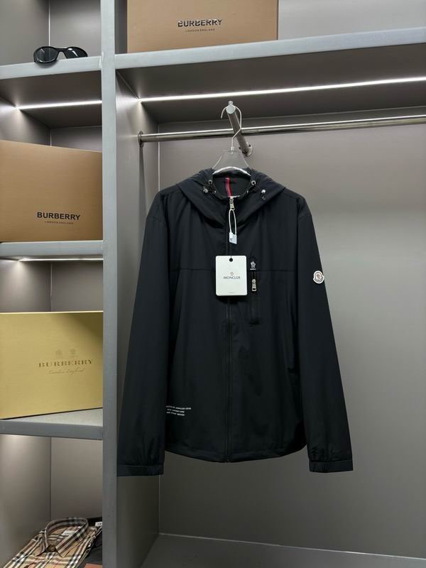 Olive green Moncler hooded nylon windbreaker jacket with a full zip closure and a black classic Moncler logo patch on the left sleeve.