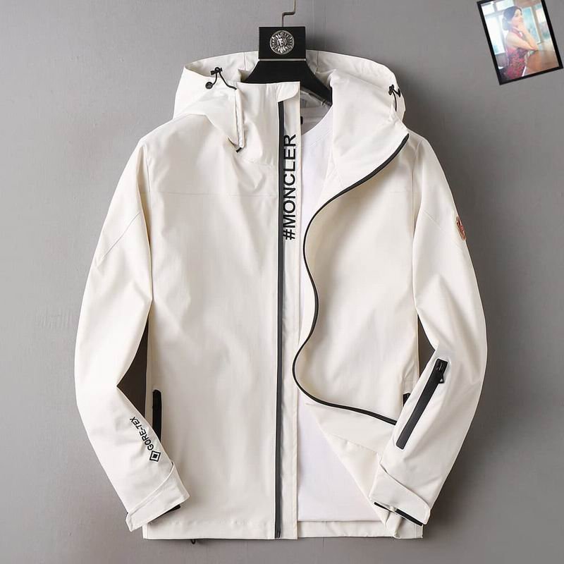 White GORE-TEX Moncler hooded technical jacket with black zipper and stripe featuring '#MONCLER' text. GORE-TEX logo appears on the sleeve.