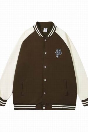 An oversized varsity jacket in a two-tone design (e.g., black body, white sleeves) with a ribbed collar and cuffs, featuring a classic, relaxed fit.