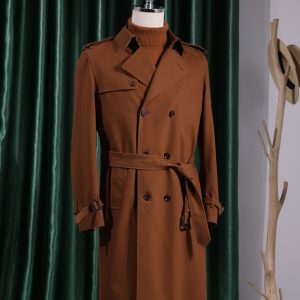 A luxury Burberry double-breasted trench coat in cognac brown, featuring classic storm flaps, shoulder epaulets, and a belted waist on a mannequin