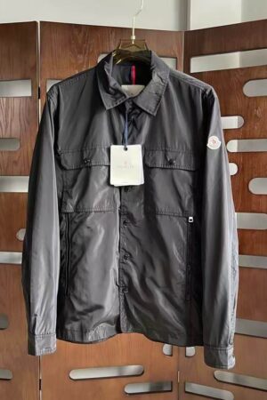 Dark grey Moncler Benoit style shirt jacket with a zipper and snap front, dual chest pockets, and a signature sleeve logo.