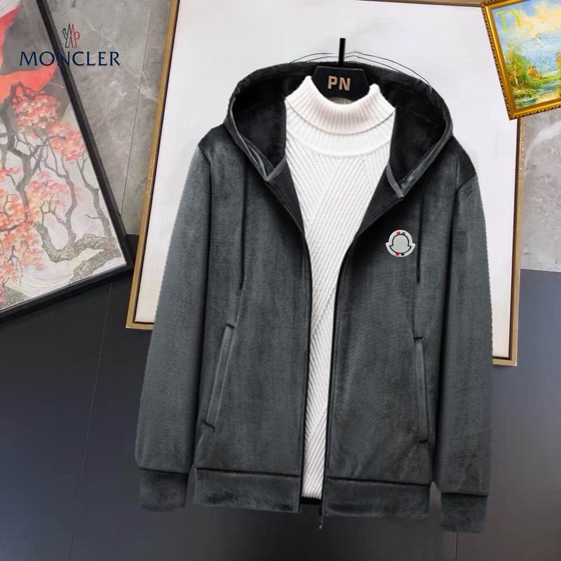 zip-up hooded jacket made of a soft fleece or velour material, featuring a white turtleneck underneath and a small circular black and white logo patch on the left chest.