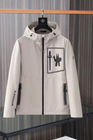 Moncler Grenoble style hooded jacket with black zipper accents and a large chest graphic, hanging on a black hanger.