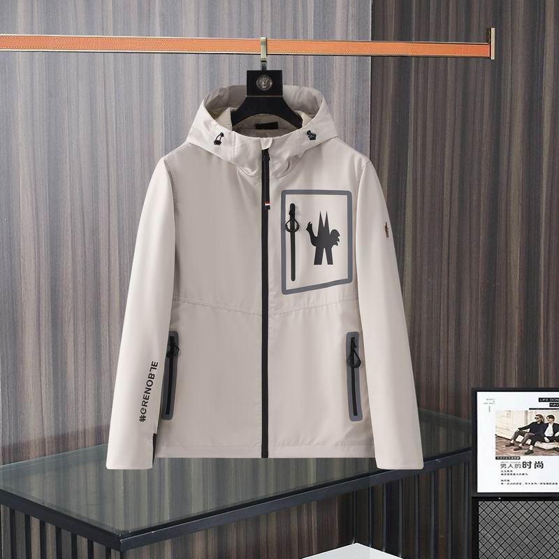 Moncler Grenoble style hooded jacket with black zipper accents and a large chest graphic, hanging on a black hanger.