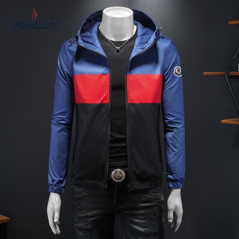 Tricolor Moncler jacket with blue top, red middle, and black bottom panels, featuring a hooded design and signature sleeve logo.