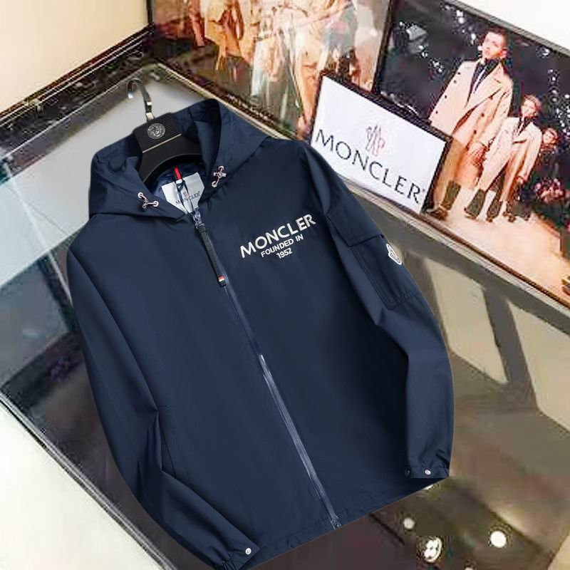Black Moncler-style hooded jacket with "Founded in 1952" text on the chest and a utility pocket with a logo patch on the sleeve.