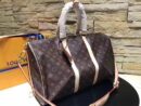 A high-quality Louis Vuitton inspired Keepall Bandoulière travel bag in brown monogram canvas with cream leather handles and a matching shoulder strap.