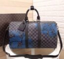 A high-quality Louis Vuitton inspired Nemeth Keepall travel bag in Damier Graphite canvas with blue rope illustrations and black leather trim.
