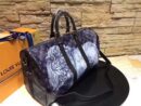 A high-quality Louis Vuitton inspired Chapman Brothers Keepall bag in navy Monogram Savane canvas with white animal sketches and black leather handles.