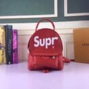A high-quality Louis Vuitton x Supreme inspired mini backpack in red textured Epi leather with white branding, a front zip pocket, and silver hardware.