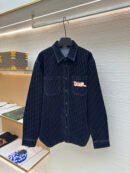 A dark navy denim button-down overshirt featuring an all-over Dior Oblique monogram pattern and a red script "Dior" patch on the chest.