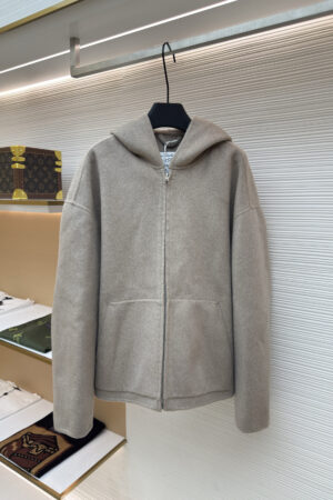 A high-quality taupe wool-blend zip-up hoodie with an oversized fit hanging in a boutique display.