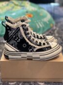 Side view of xVessel high-top sneakers with a black and white paisley pattern, frayed edges, and a thick layered white midsole.