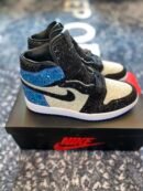 A side profile view of a black, white, and blue glitter-covered high-top sneaker on a Nike box.