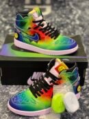 : A pair of rainbow tie-dye J Balvin x Air Jordan 1 sneakers with jagged edges on a black box.