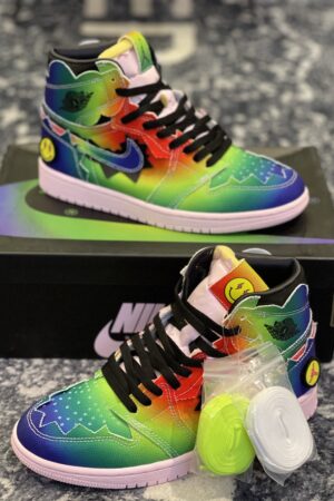 : A pair of rainbow tie-dye J Balvin x Air Jordan 1 sneakers with jagged edges on a black box.