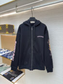 Black Chrome Hearts zip-up hoodie on a hanger featuring a pink scroll logo on the chest, pink graphics on the sleeves, and a silver dagger zipper pull.