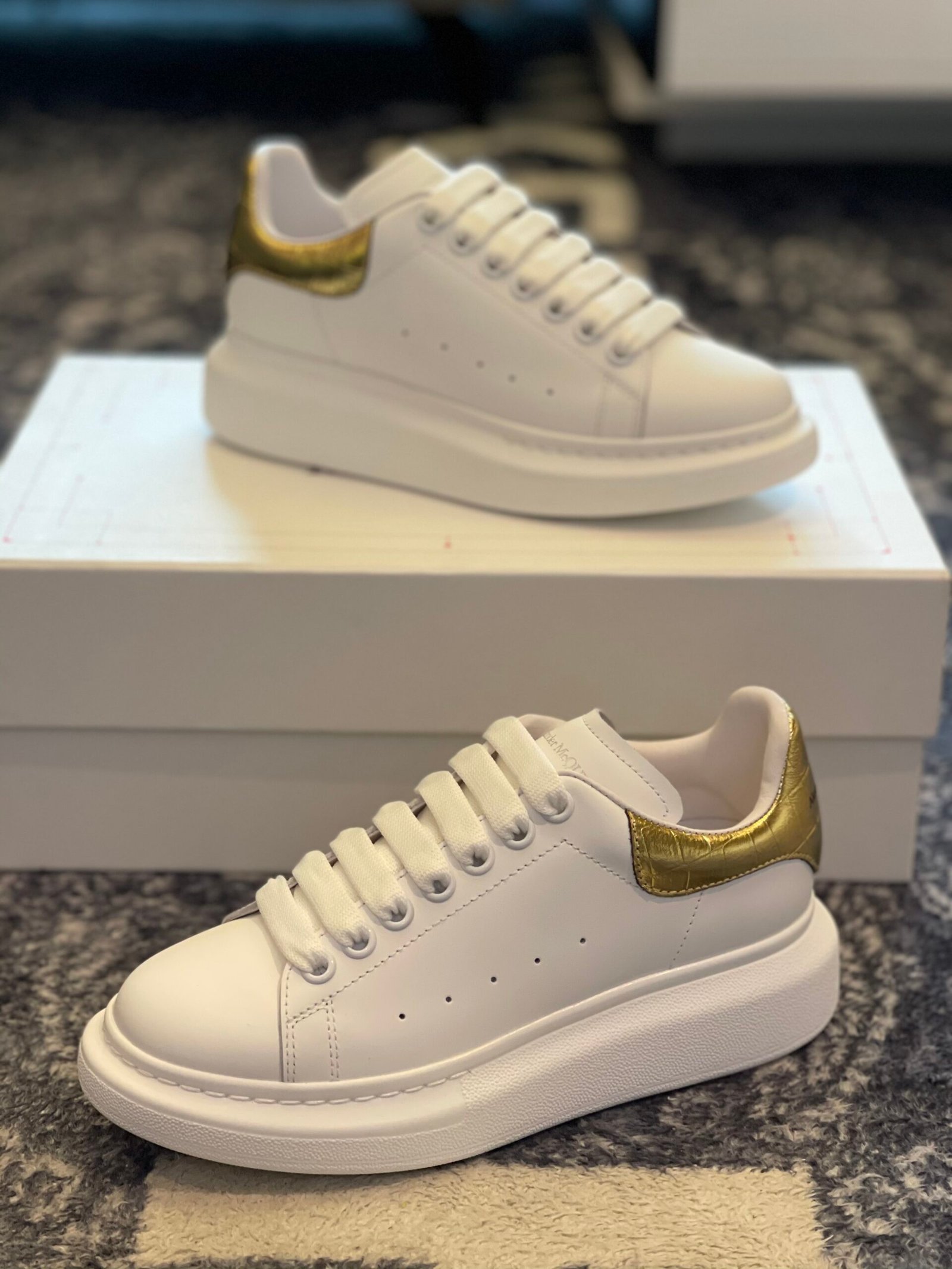 Men's Luxury Sneakers, Alexander McQueen, White and Gold Shoes, Designer Footwear, Oversized Sneakers, Croc-Effect Leather, Streetwear Fashion, Premium Men's Style, Metallic Gold Accents, Luxury Wardrobe Essentials.