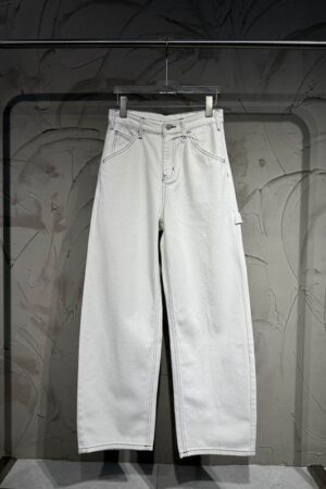 Rear view of off-white wide-leg denim pants hanging on a rack, featuring a back waist buckle and embroidery.