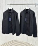 Two premium men's long-sleeve black formal shirts hanging on a rack, featuring tonal black monogram embroidery detailing on the pointed collars and cuffs.