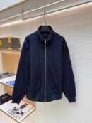 A navy blue zip-up track jacket featuring tonal Dior Oblique monogram patterns on the shoulders and sleeves.