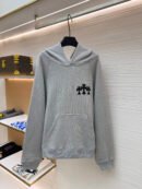 Heather grey Chrome Hearts heavyweight hoodie on a hanger featuring three black tonal cross patches on the chest and a crossover neck hood.