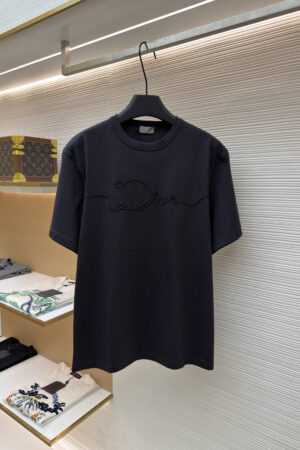 A black short-sleeve T-shirt featuring a tonal black raised rope-style script embroidery of the Dior logo across the chest