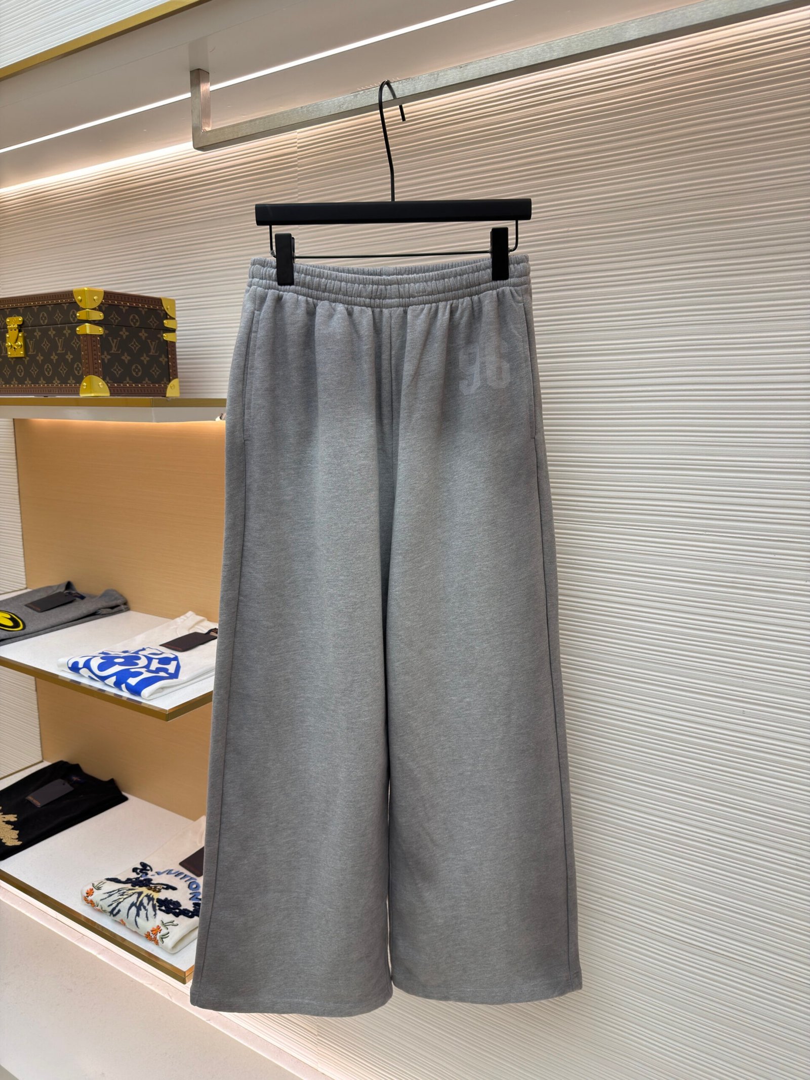 A pair of light grey Acne Studios wide-leg sweatpants with a faint 96 logo print on the thigh.