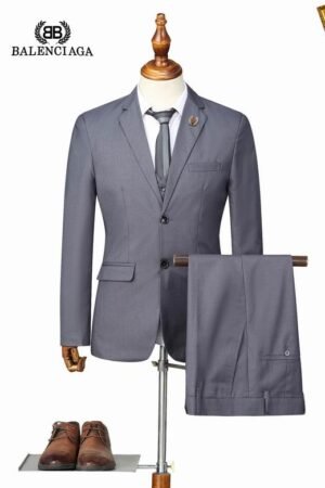A formal men's charcoal grey three-piece suit displayed on a mannequin, featuring a blazer, waistcoat, and matching trousers, inspired by high-end luxury fashion designs.