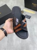 Luxury Berluti Alessandro sandals in a tobacco brown and black leather mix featuring Scritto calligraphy engraving and a sleek flat sole.