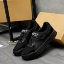 A pair of DSQUARED2 Icon low-top sneakers in all-black leather and mesh, featuring a prominent midfoot strap with white "ICON" branding, leaning against a cardboard box.