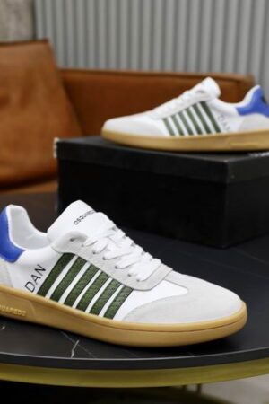 DSQUARED2 Boxer low-top sneakers in white leather with olive green side stripes, light gray suede toe caps, and a royal blue heel tab, shown on a dark table.