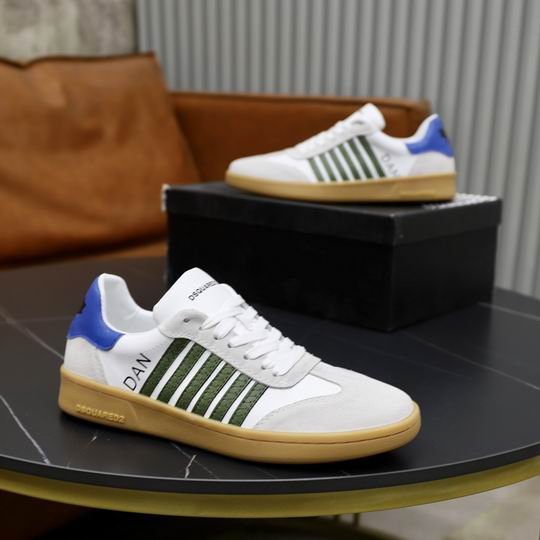 DSQUARED2 Boxer low-top sneakers in white leather with olive green side stripes, light gray suede toe caps, and a royal blue heel tab, shown on a dark table.