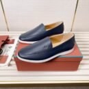 A pair of Midnight Navy smooth leather Summer Walk loafers with white rubber soles, displayed on an orange box next to authenticating materials.