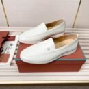 A pair of Optical White smooth leather Summer Walk loafers with white rubber soles, displayed on an orange box next to authenticating materials.
