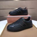 A side profile view is shown of a pair of men's premium sand beige technical mesh sneakers with matching cream suede trim, displayed next to an orange shoe box.