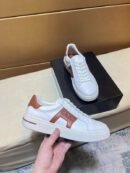 A pair of premium Loro Piana Nuages low-top sneakers crafted from smooth white leather, featuring signature Kummel brown side inserts and heel tabs.