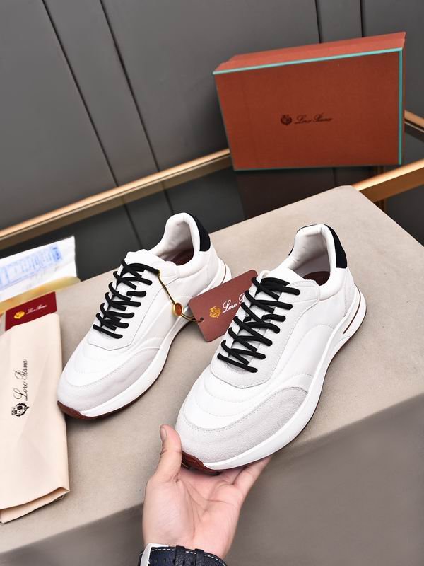 A pair of premium white Loro Piana low-top sneakers with black laces and suede trim, resting on a branded box with an attached tag.