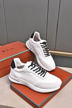A pair of premium light gray and charcoal knitted Loro Piana low-top sneakers with a sock-like collar and white soles, displayed on a table.